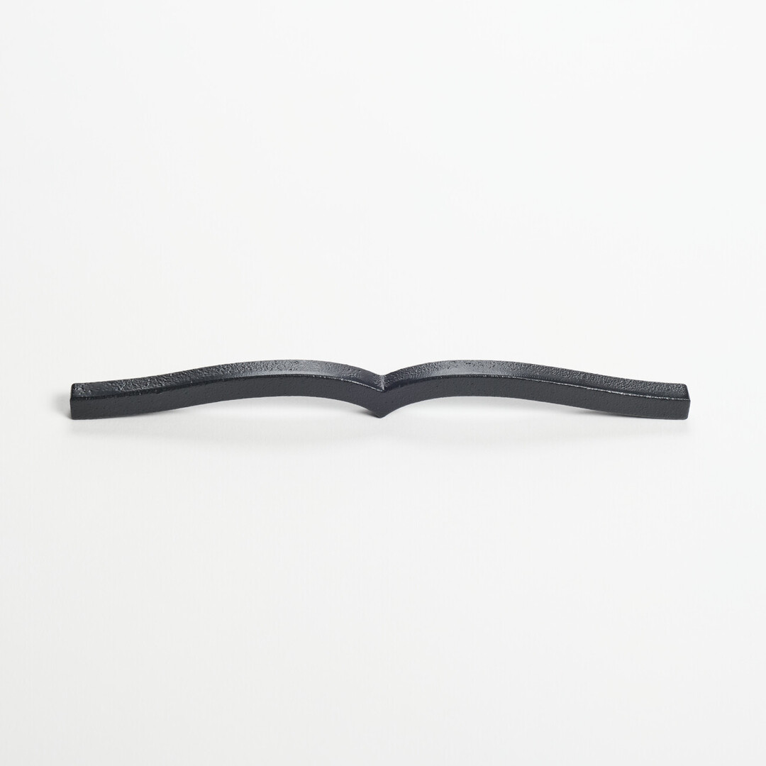 A black cast iron metal paperweight in the shape of a book from Japan House London.