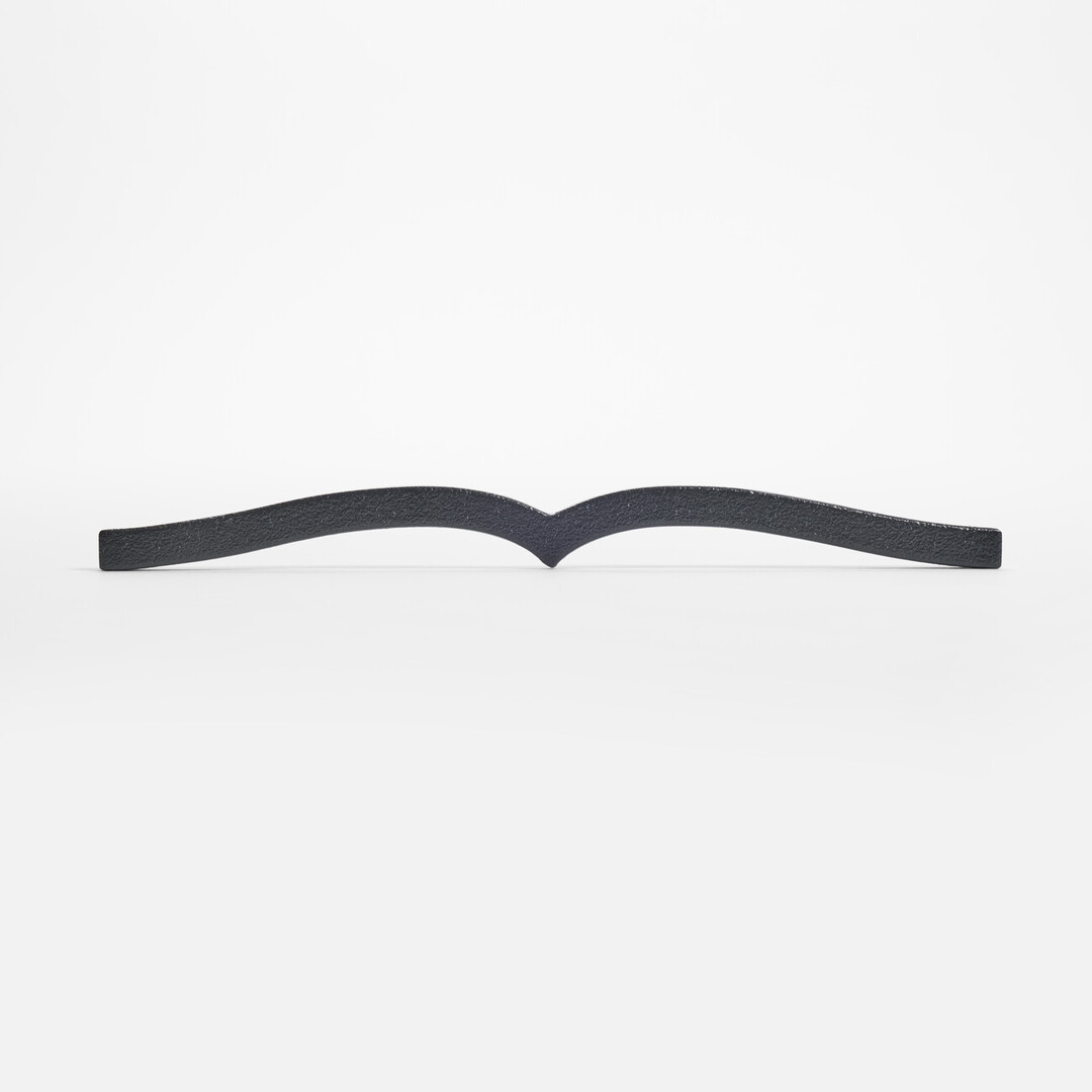 A black cast iron metal paperweight in the shape of a book from Japan House London.