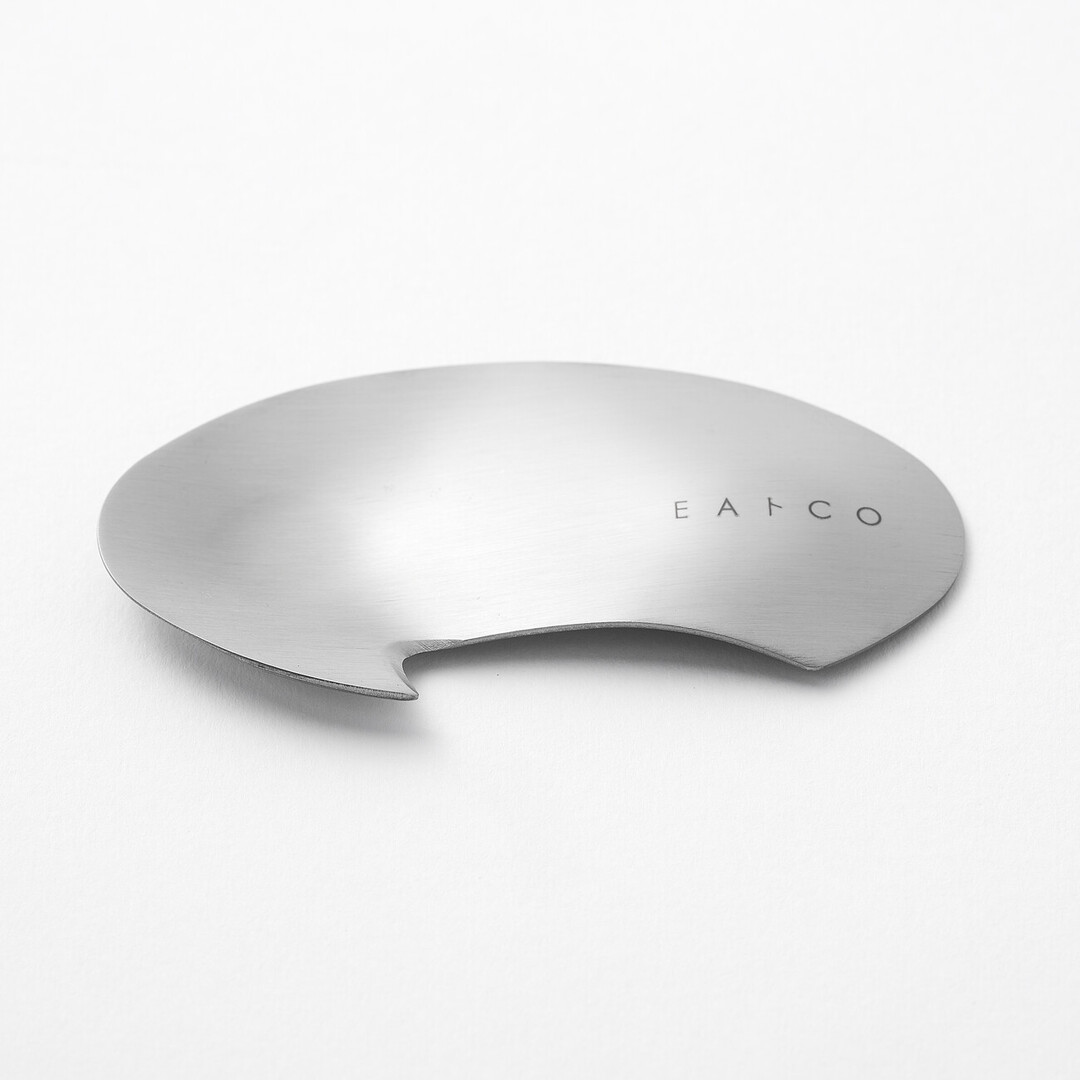 A silver circular utensil with a hook to peel avocados by Eatoco from Japan House London.