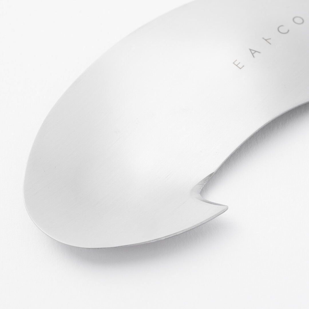 A silver circular utensil with a hook to peel avocados by Eatoco from Japan House London.