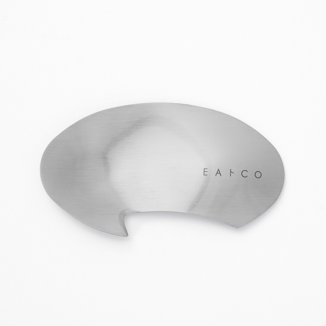 A silver circular utensil with a hook to peel avocados by Eatoco from Japan House London.