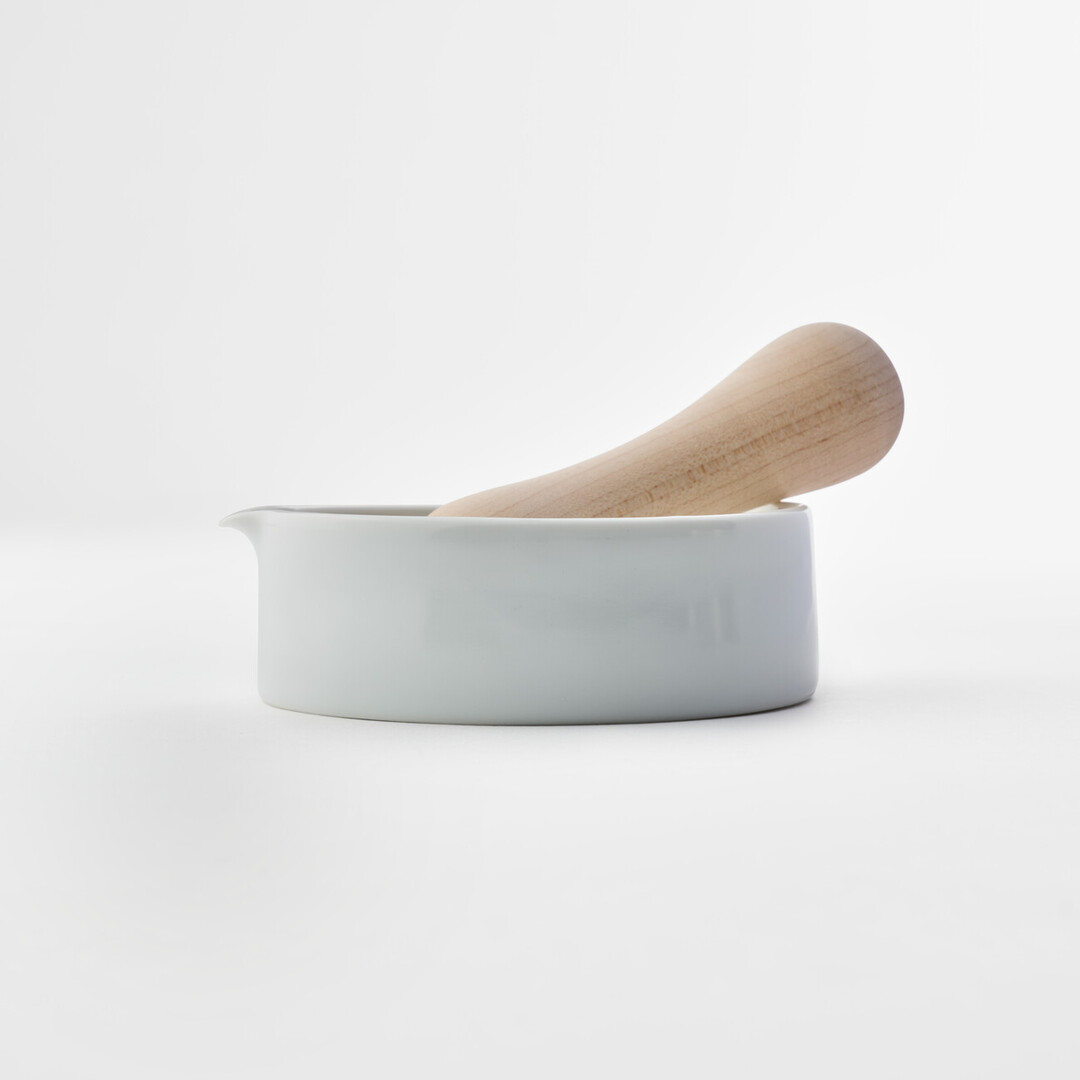 A white porcelain mortar and wooden pestle by Kihara from Japan House London.
