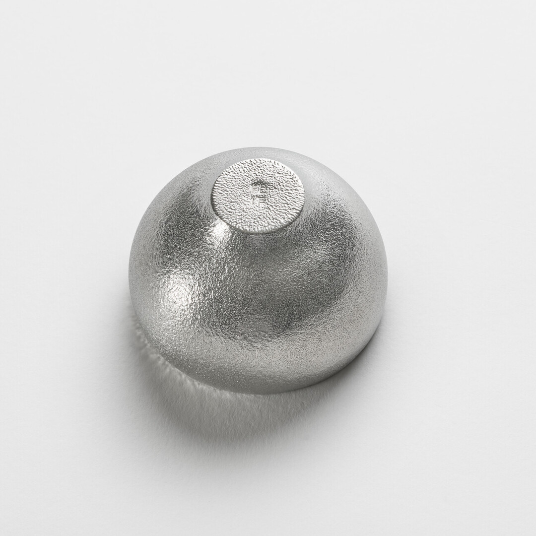 The underside of the rounded tin sake cup by Nousaku from Japan House London.