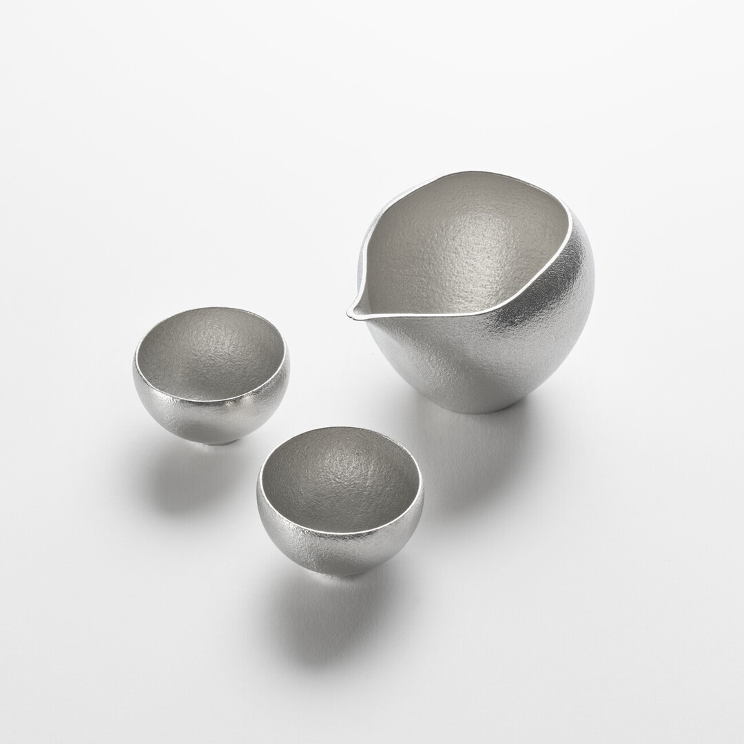 Rounded Sake tin pitcher and two tin sake cup set by Nousaku from Japan House London.