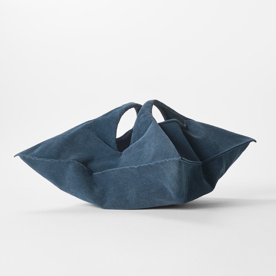 A navy blue bag shaped in a diamond shape by mate mono from Japan House London.