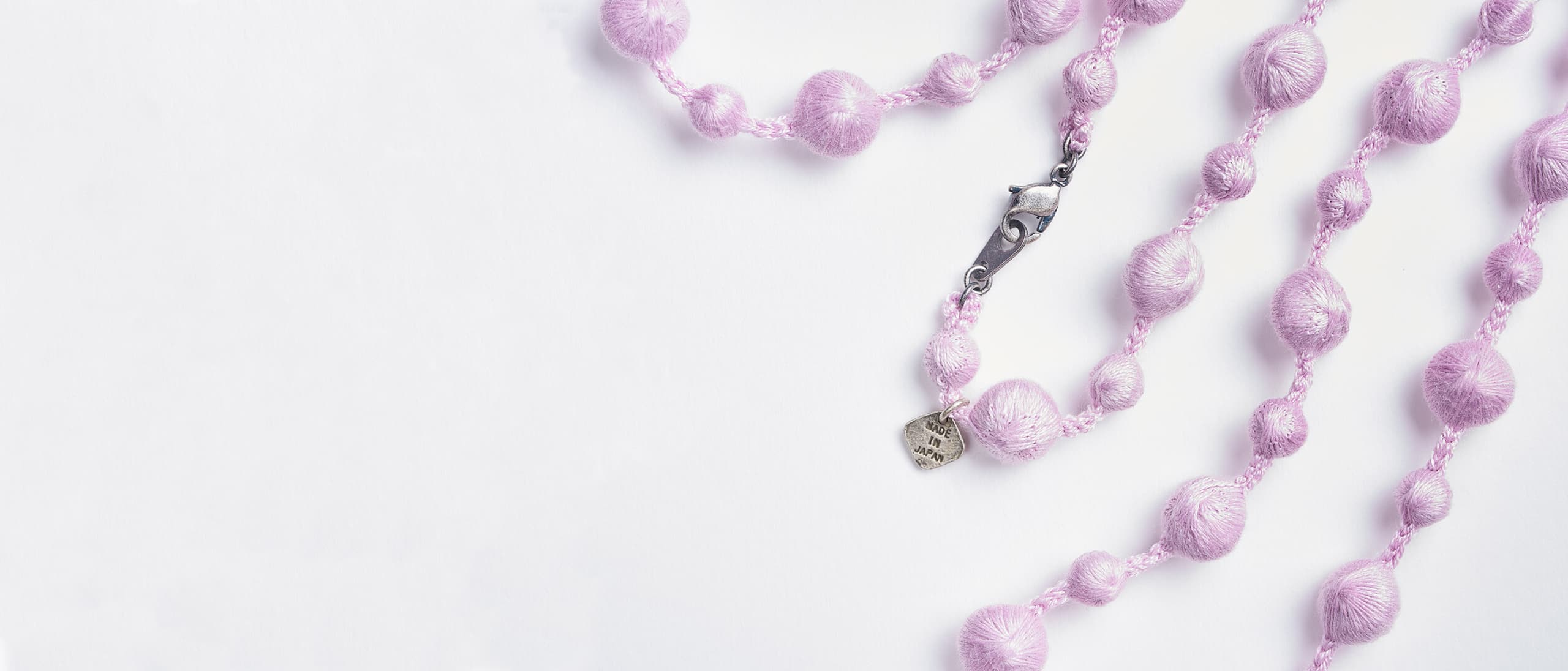 Lilac necklace created from embroidered spheres by Triple O from Japan House London.