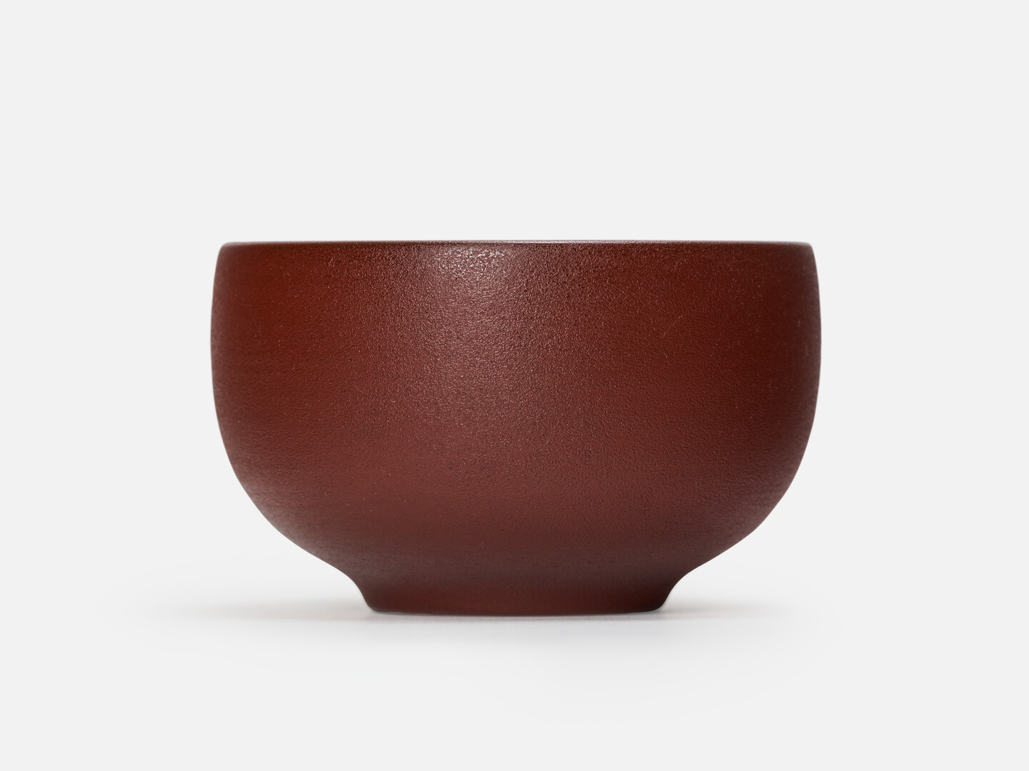A red rounded lacquered bowl with a matt surface by Wajima Kirimoto from Japan House London.