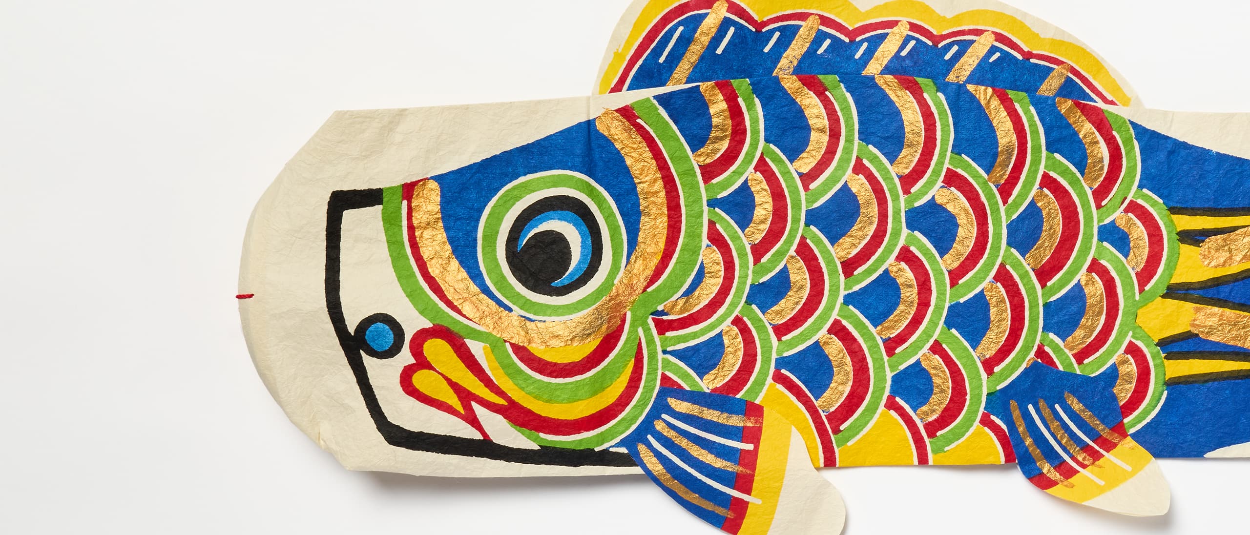 A blue koinobori with gold, red, blue and yellow markings from Japan House London.