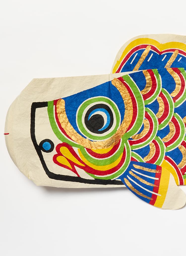 A blue koinobori with gold, red, blue and yellow markings from Japan House London.