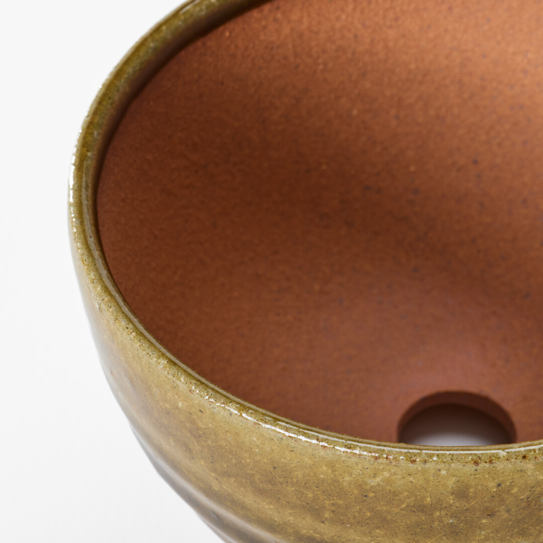 A Shigaraki-yaki plant pot with a hole in the middle from Japan House London