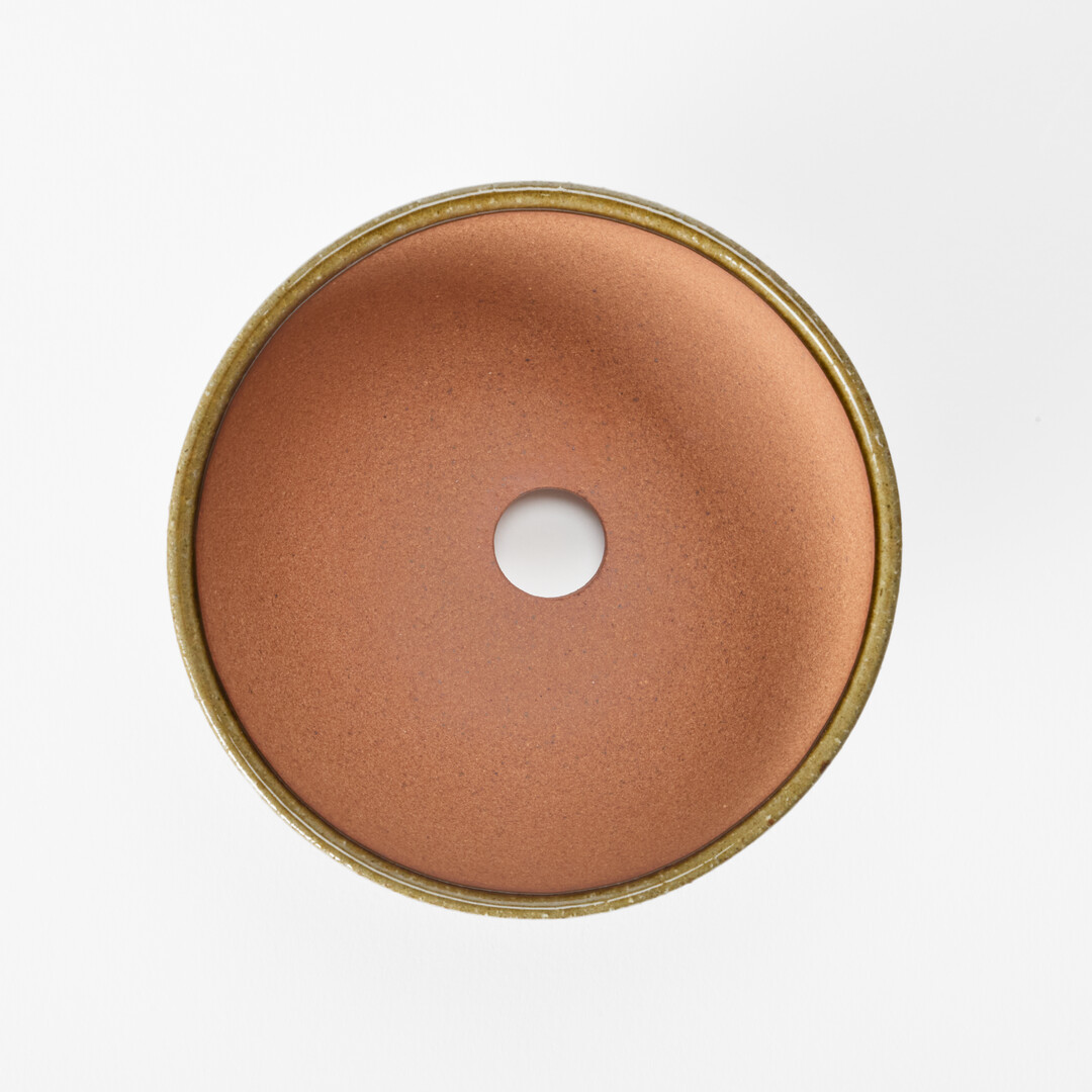 A Shigaraki-yaki plant pot with a hole in the middle from Japan House London