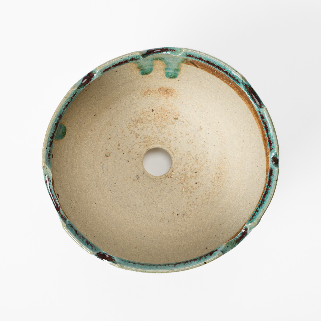 A Shigaraki-yaki plant pot with a hole in the middle from Japan House London