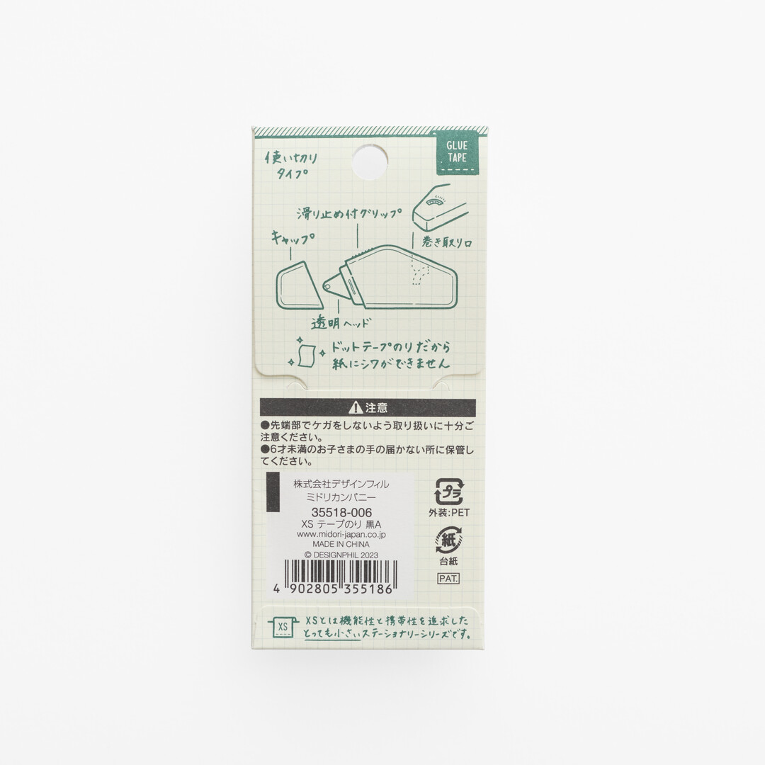 White packaging with green writing explaining Midori XS Glue Tape - Black from Japan House London.