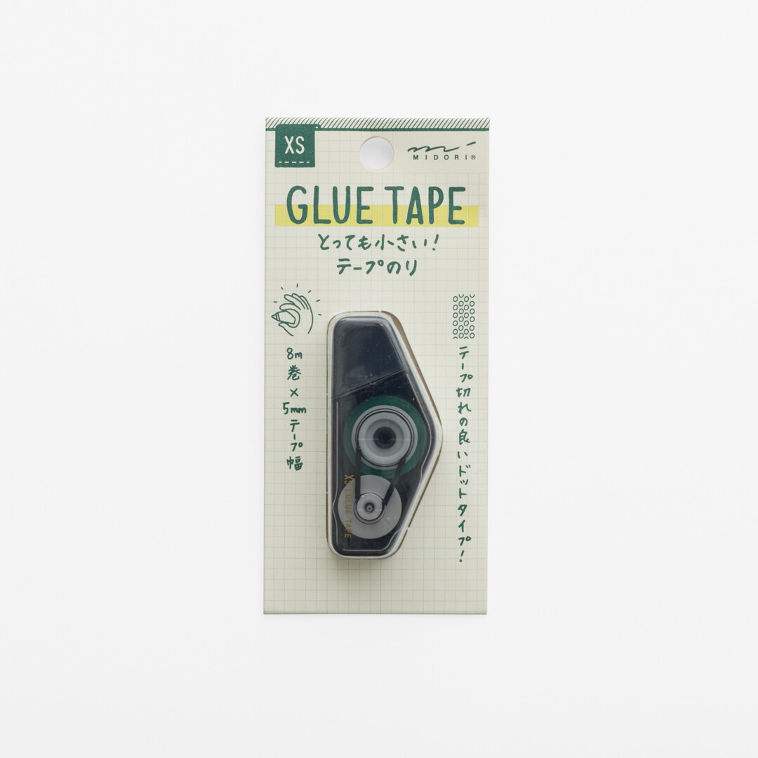 White packaging with green writing explaining Midori XS Glue Tape - Black from Japan House London.