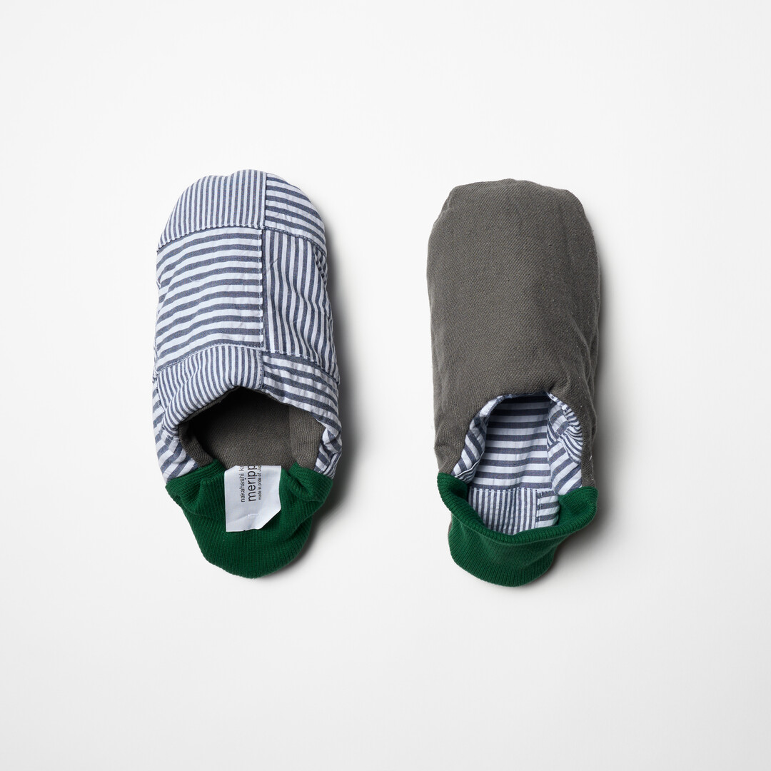 Merippa slipper with one side, blue and white striped body, the other side, grey body and green heel from Japan House London.