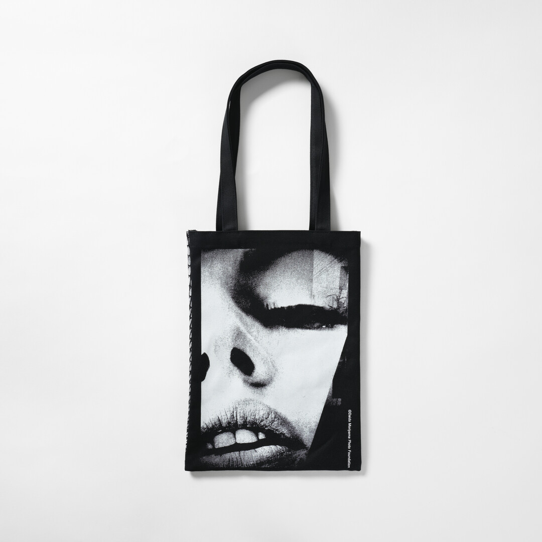 A black tote bag with Moriyama Daido's photography of a woman's face from Japan House London.