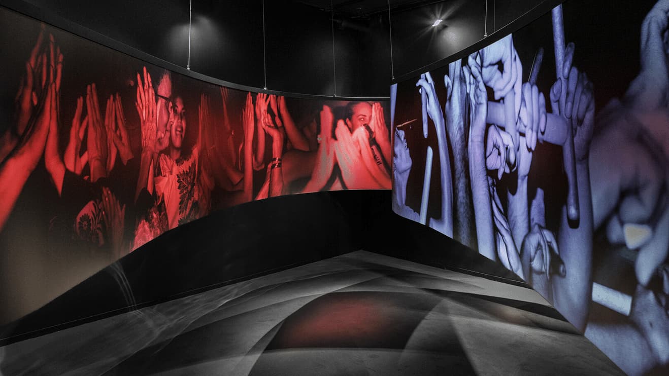 A black room with two long photographs creating a corridor from Japan House London exhibition, Kyotographie: Kawada Kikuji x Iwane Ai