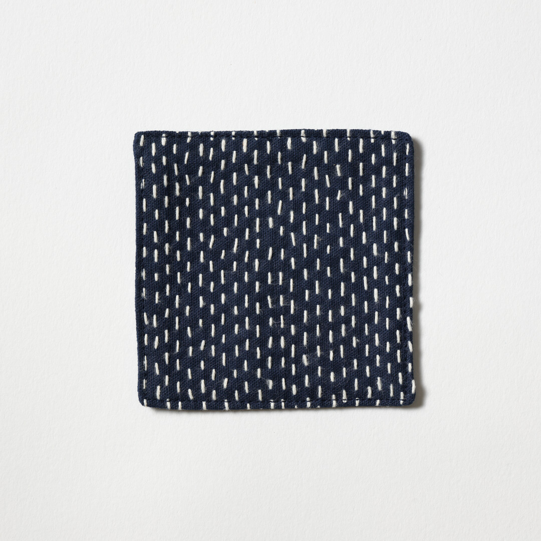 A sashiko coaster in navy by Teras from Japan House London