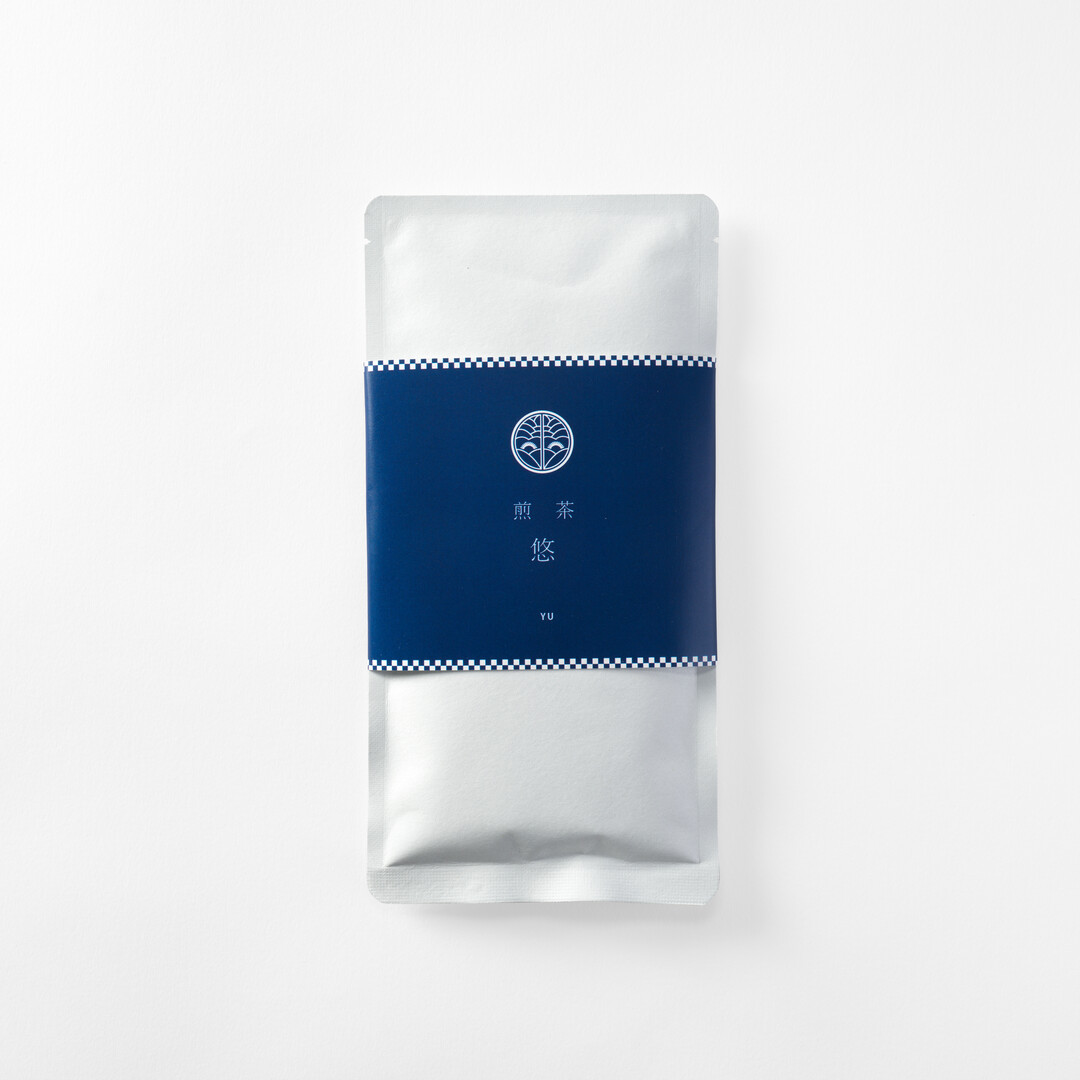A silver package with navy blue label holding Sencha Tea - Yu teabags from Japan House London