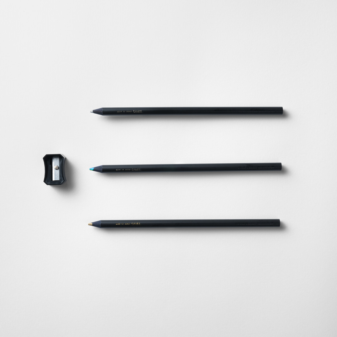 A set of three coloured pencils in black and sharpener by CDT from Japan House London.
