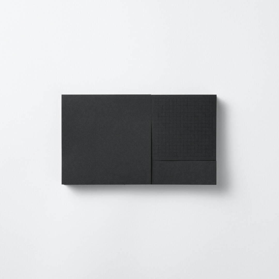A rectangular black memo pad with three sizes of memos by CDT from Japan House London.