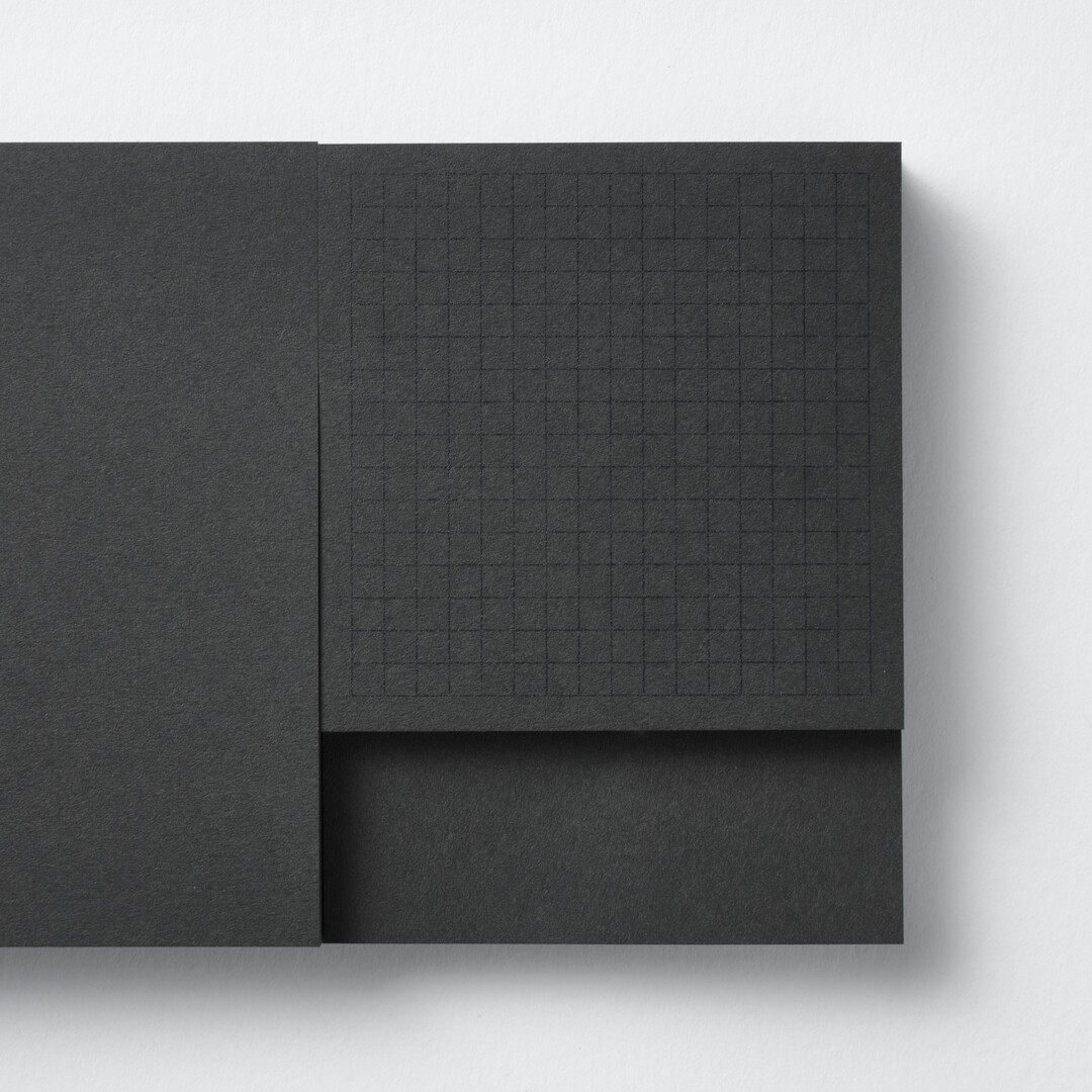 A rectangular black memo pad with three sizes of memos by CDT from Japan House London.