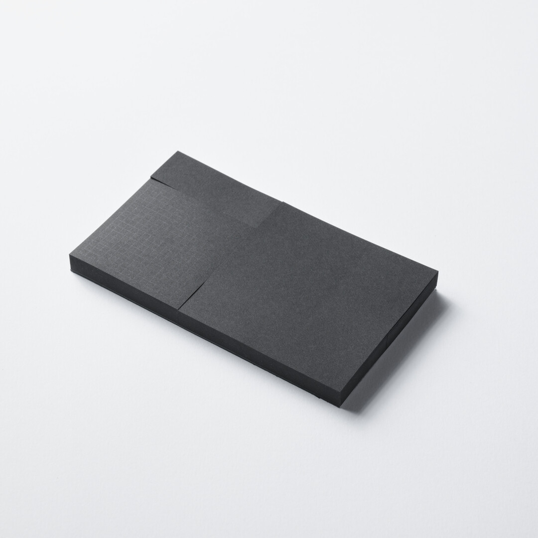 A rectangular black memo pad with three sizes of memos by CDT from Japan House London.