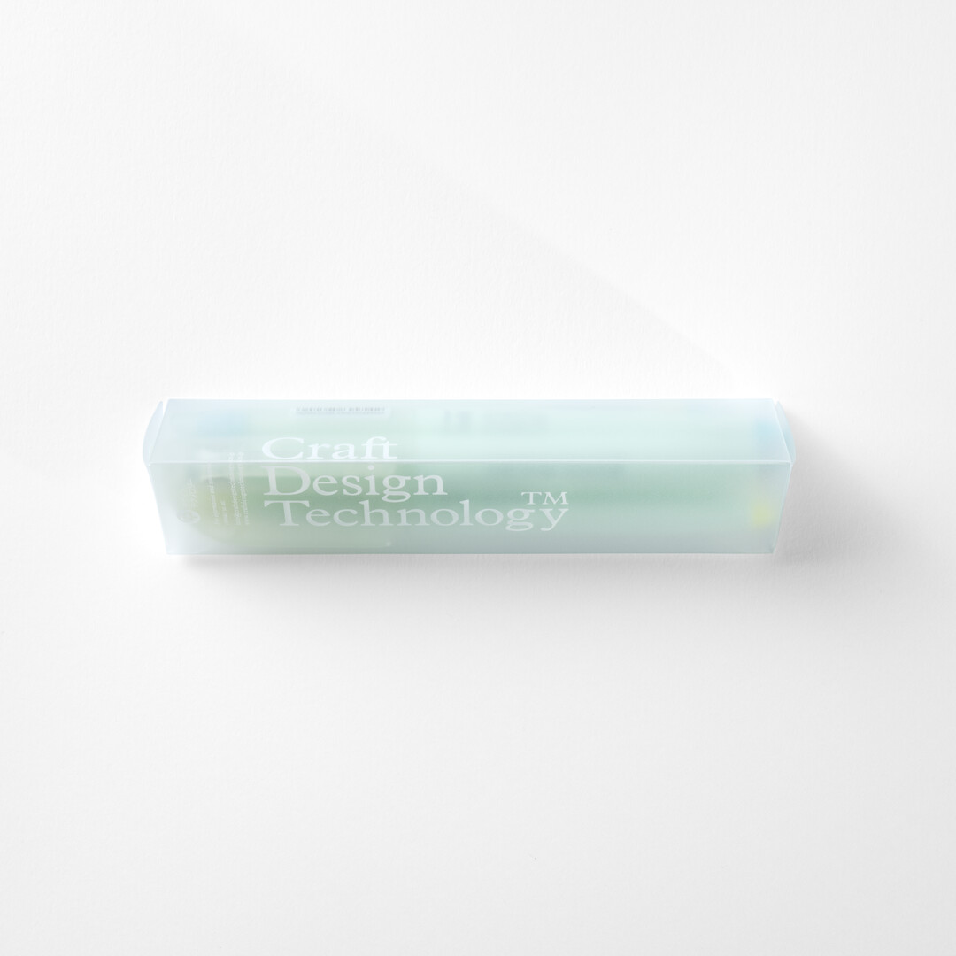 A translucent triangular box holding a set of three highlighters in grey, blue and yellow by CDT from Japan House London.