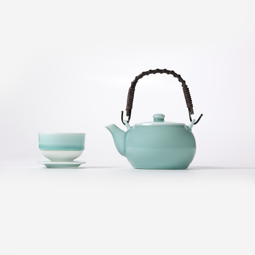Light turquoise glazed teapot and teacup with saucer from Japan House London.