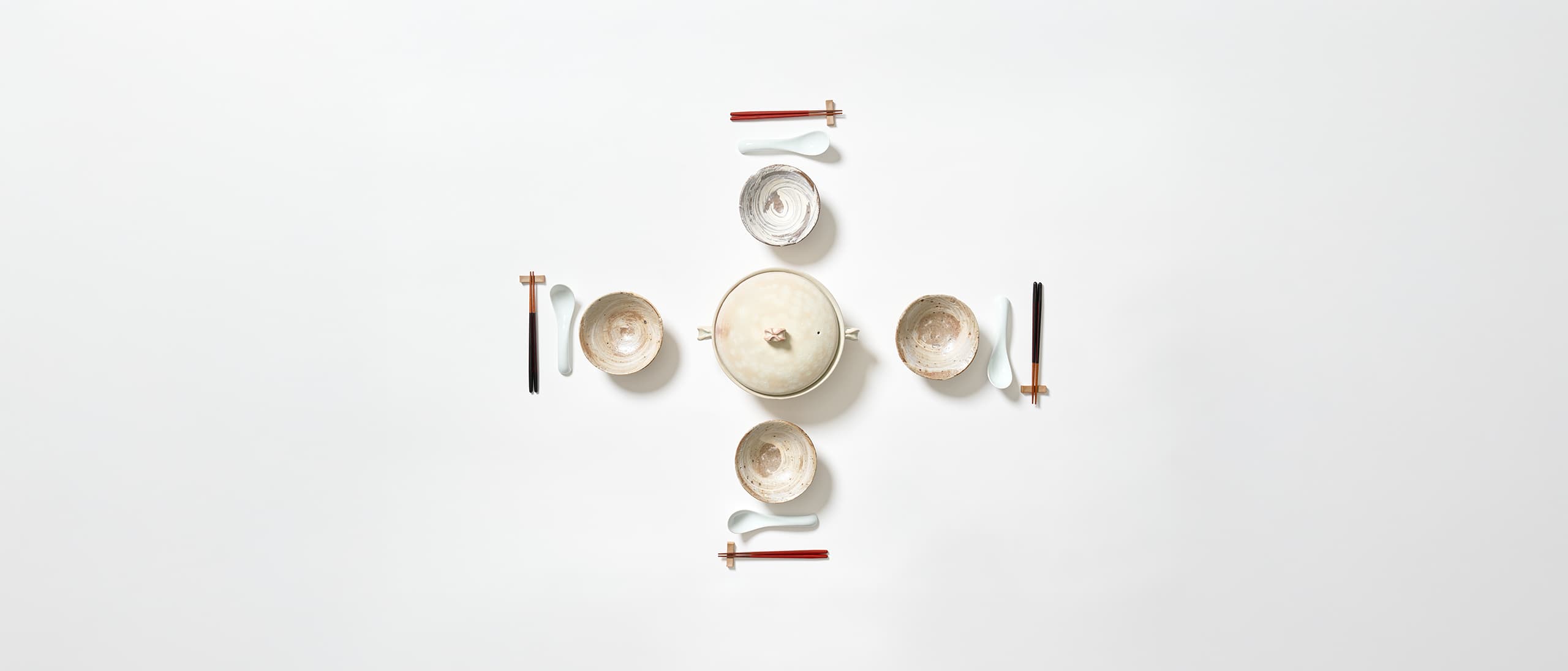 A donabe with four ceramic bowls, four pairs of lacquered chopsticks and rests with porcelain spoons from Japan House London.
